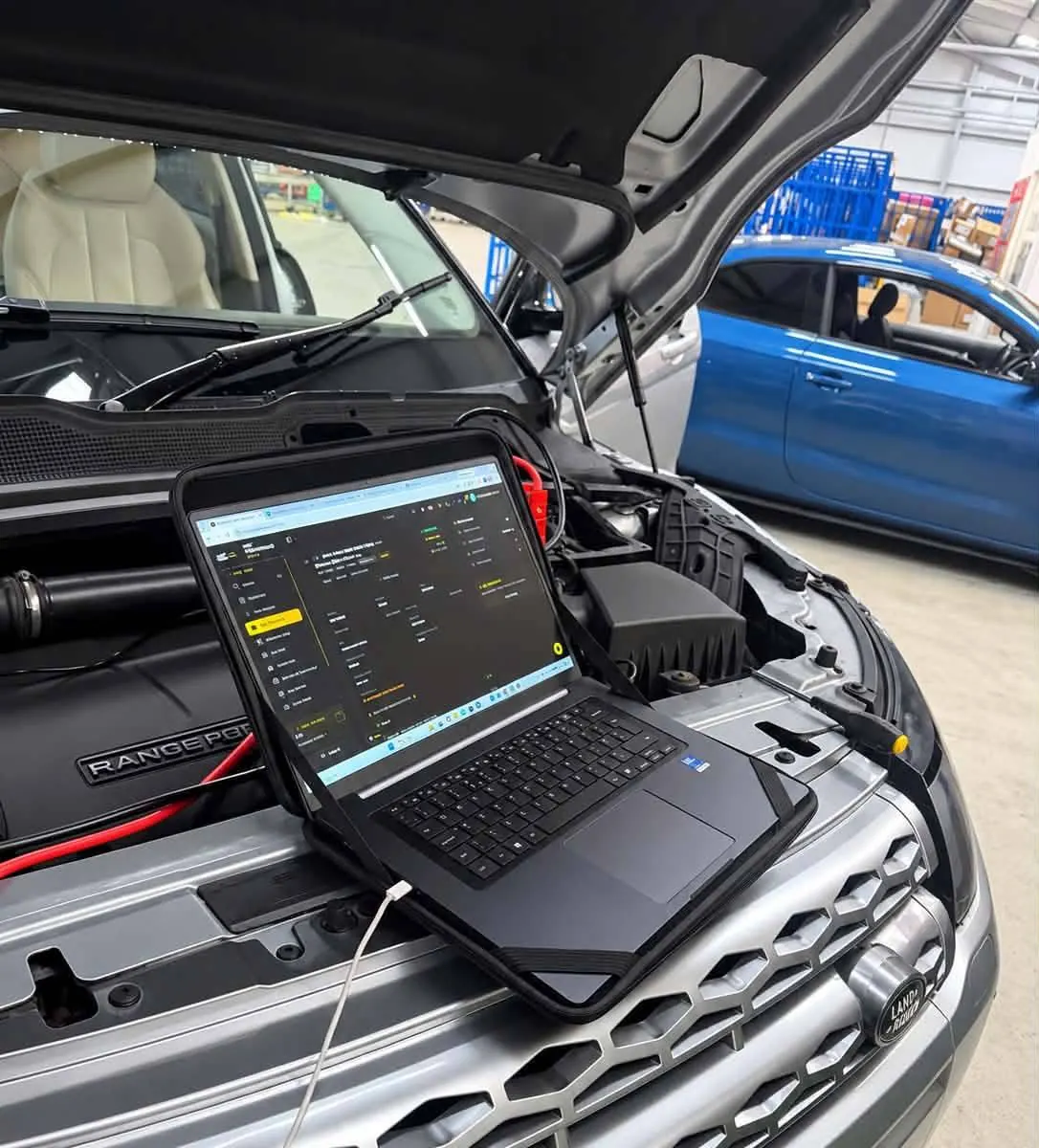 A laptop running tuning software on the front of a Range Rover Evoque